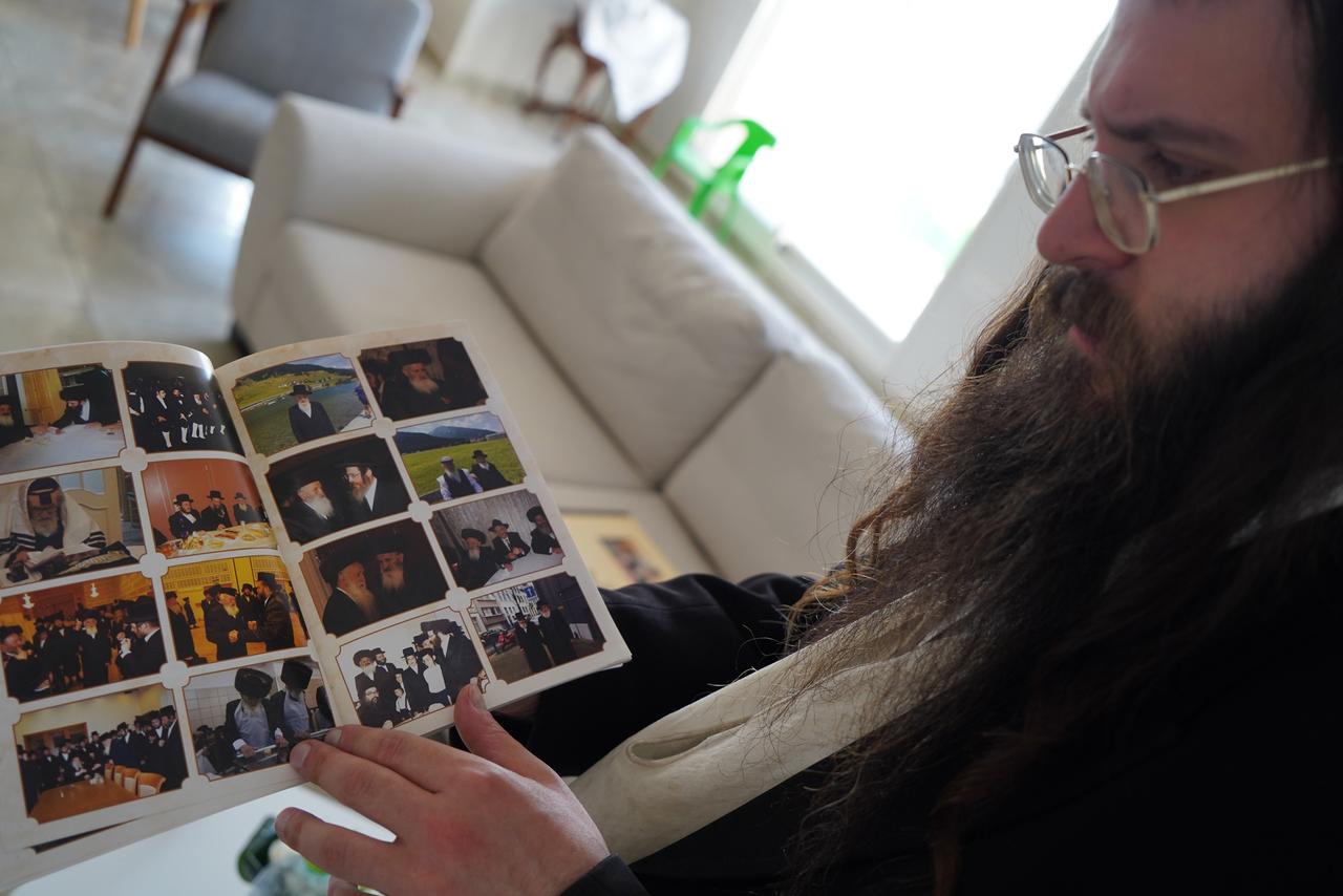 Ein Enkel von Sander Fried hält ein Fotoalbum in der Hand.