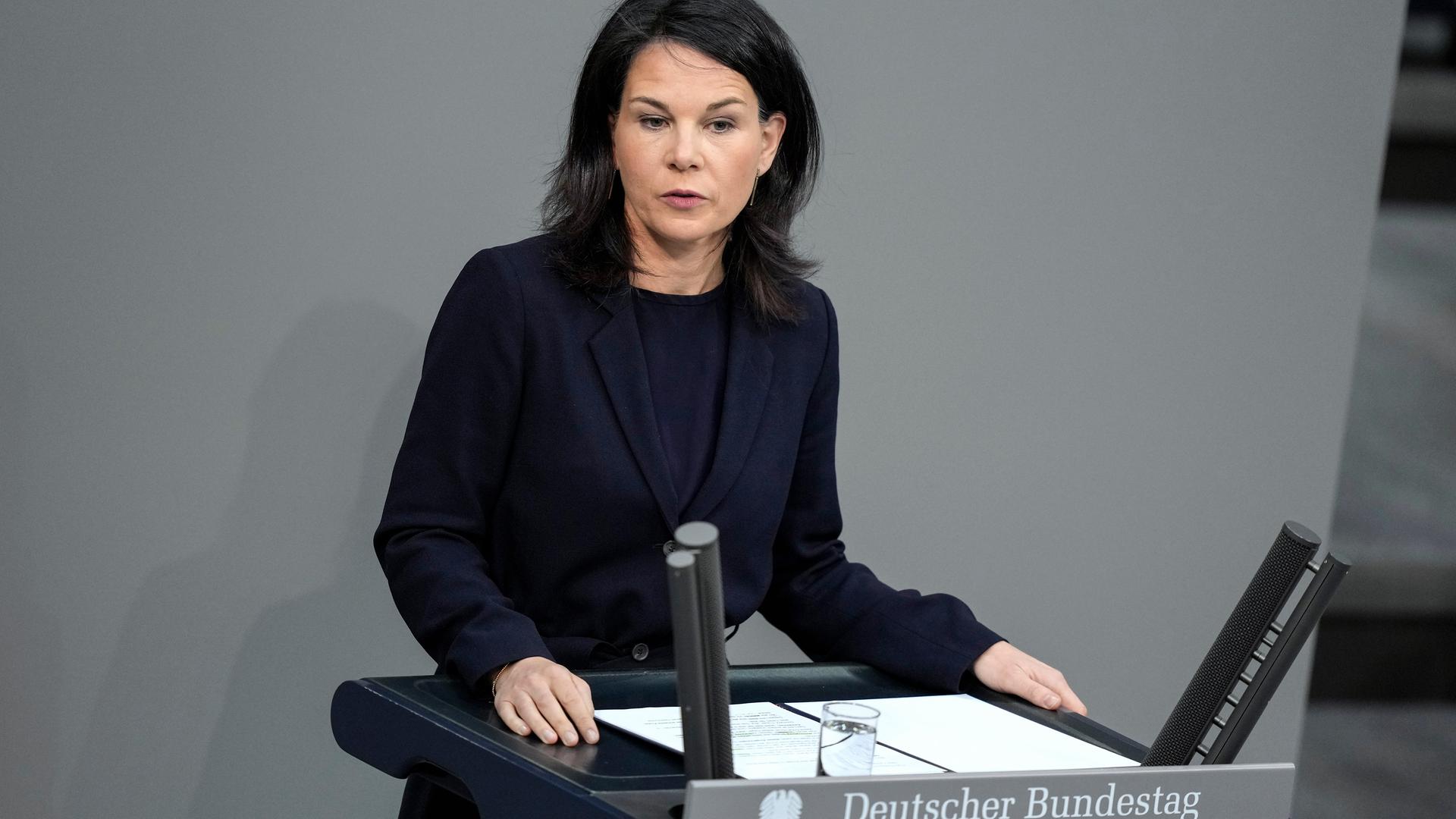 Bundesaußenministerin Baerbock steht im Bundestag hinter einem Rednerpult. Bundesaußenministerin Baerbock steht im Bundestag hinter einem Rednerpult.