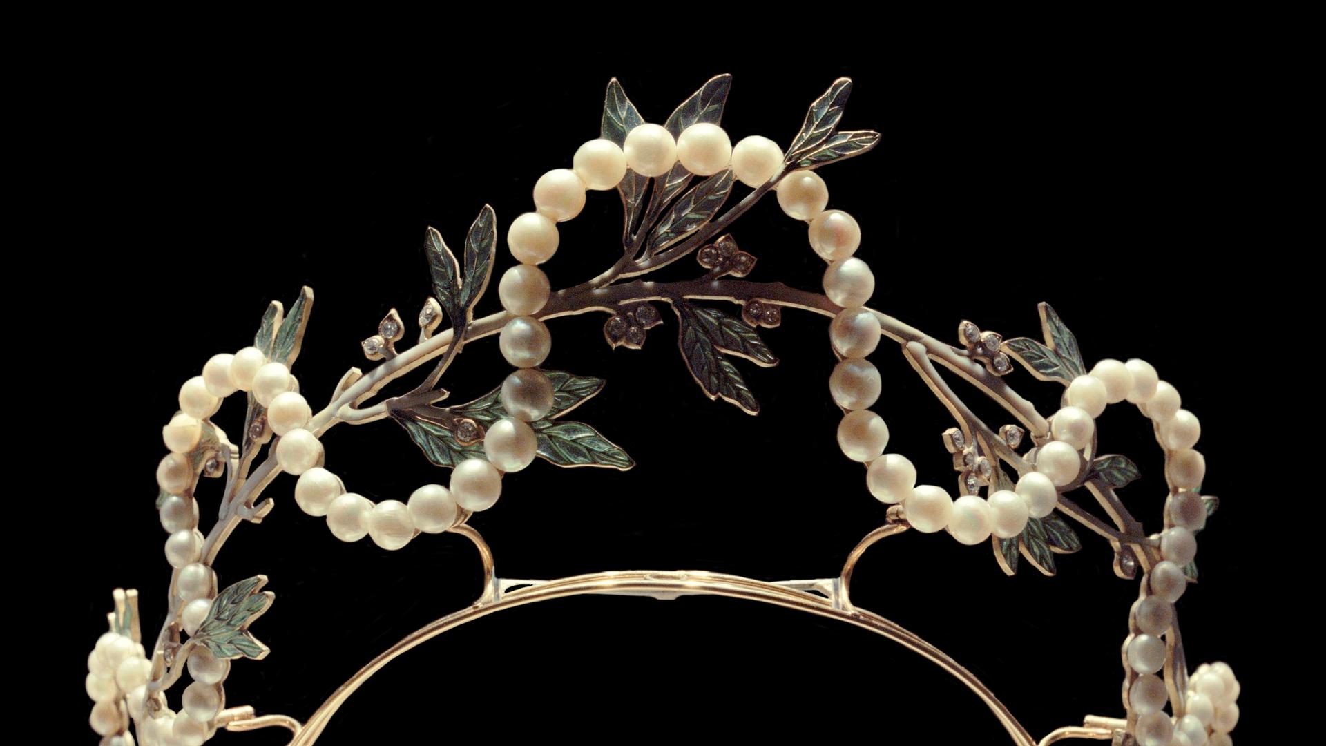 Eine Krone aus einem silbernen Reif ist mit vielen Perlen und Glas verziert. Das Glas hat die Form von Blättern. Eine Krone aus einem silbernen Reif ist mit vielen Perlen und Glas verziert. Das Glas hat die Form von Blättern.