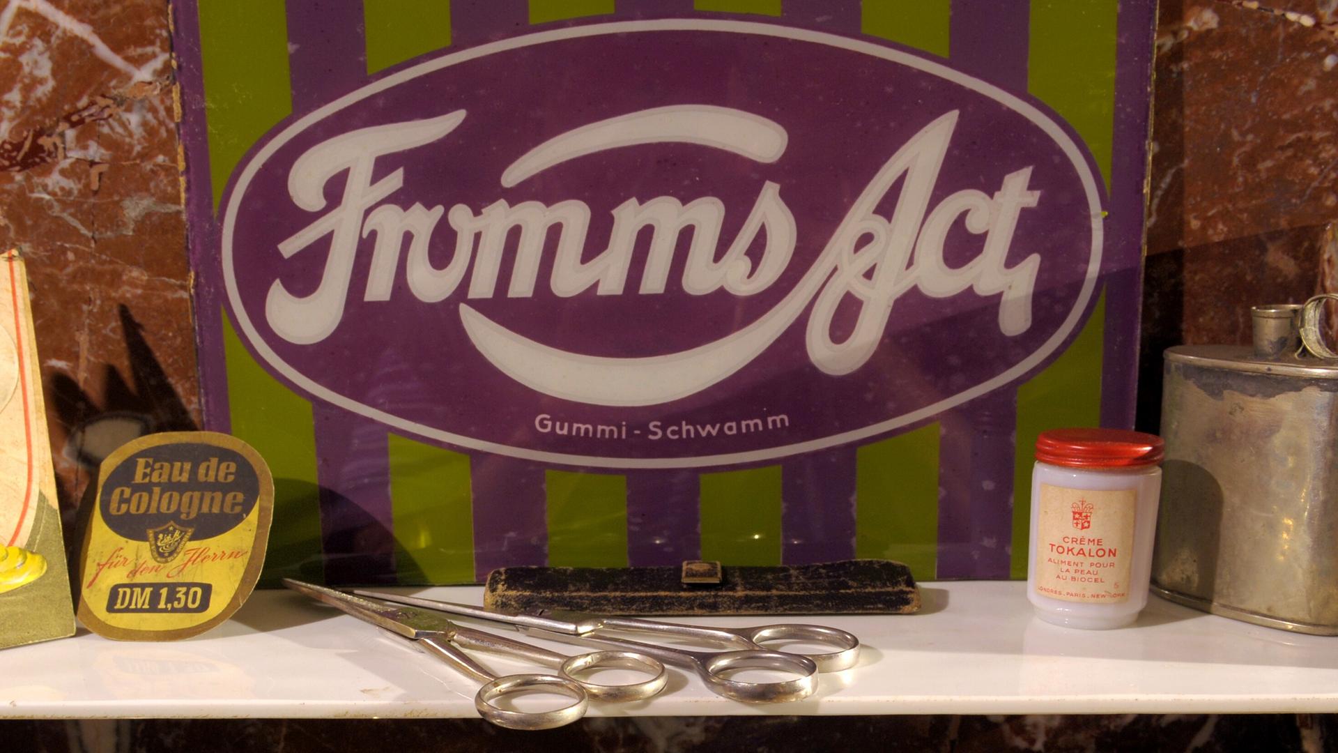 Im Schaufenster eines Friseursalons wirbt ein Schild für die Kondome "Fromms Act". Im Schaufenster eines Friseursalons wirbt ein Schild für die Kondome "Fromms Act".