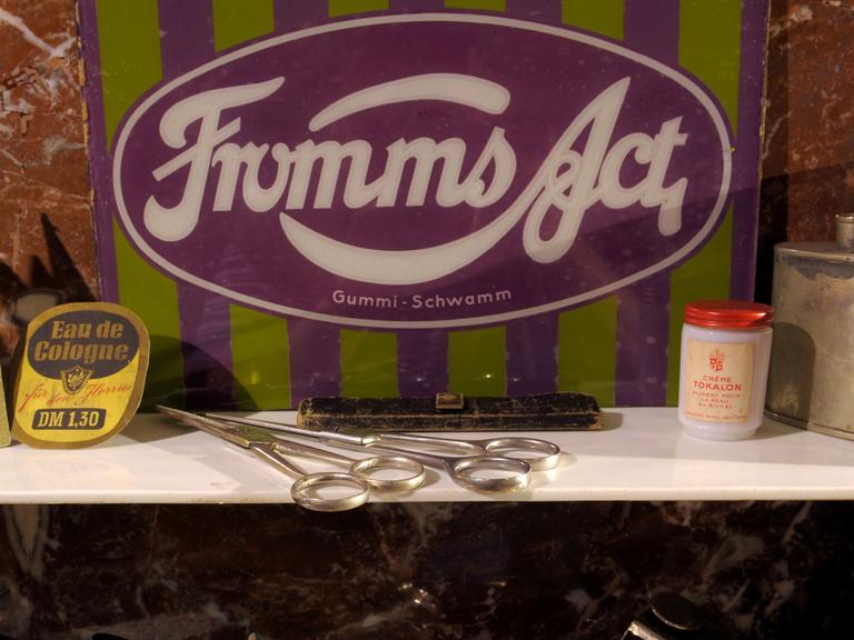Im Schaufenster eines Friseursalons wirbt ein Schild für die Kondome "Fromms Act".