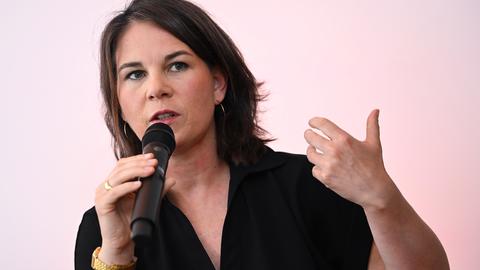 Außenministerin Annalena Baerbock hält ein Mikrofon und unterstreicht ihre Worte mit einer abwägenden Geste.