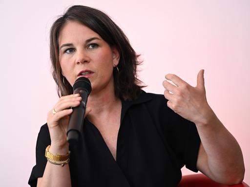 Außenministerin Annalena Baerbock hält ein Mikrofon und unterstreicht ihre Worte mit einer abwägenden Geste.
