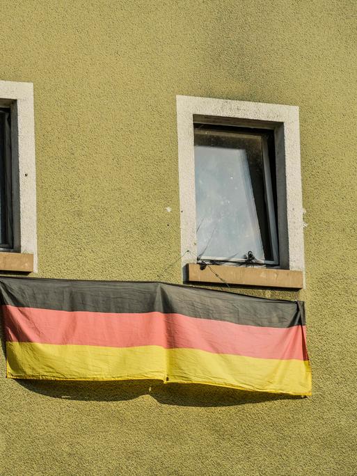 An einem Fenster in Wiesbaden hängt die Deutschlandfahne