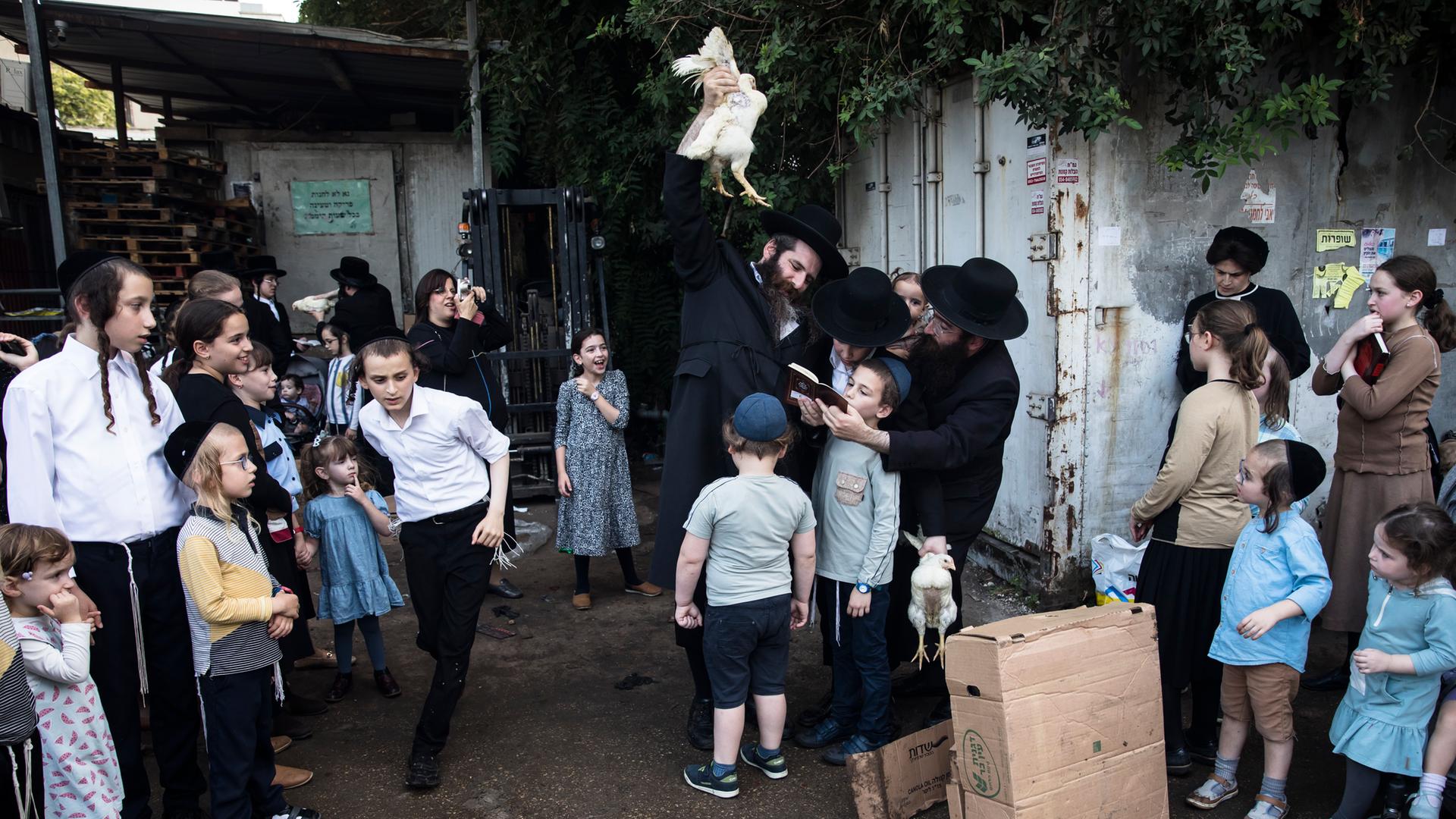 Orthodoxe Juden aller Altersklassen beim Kaparot-Ritual mit einem Huhn am 3. Oktober 2022 in der Stadt Bnei Berak, nordöstlich von Tel Aviv.