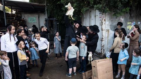 Orthodoxe Juden aller Altersklassen beim Kaparot-Ritual mit einem Huhn am 3. Oktober 2022 in der Stadt Bnei Berak, nordöstlich von Tel Aviv.