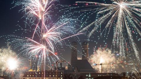 Feuerwerksraketen erleuchten in der Silvesternacht den Himmel über München