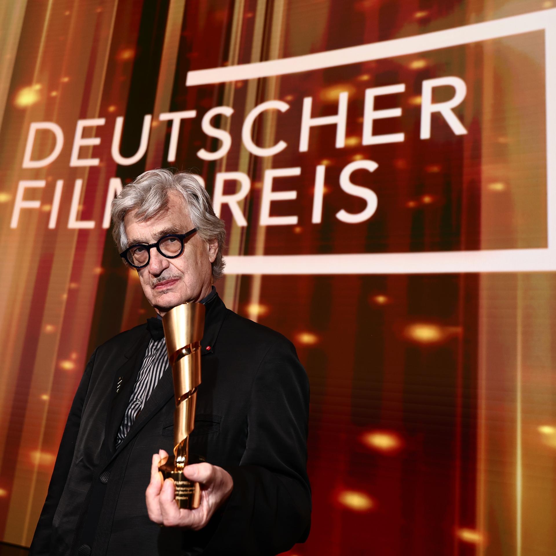 Wim Wenders, Regisseur, hält nach der Verleihung des Deutschen Filmpreises im Palais am Funkturm seinen Ehrenpreis des Deutschen Filmpreises in der Hand.