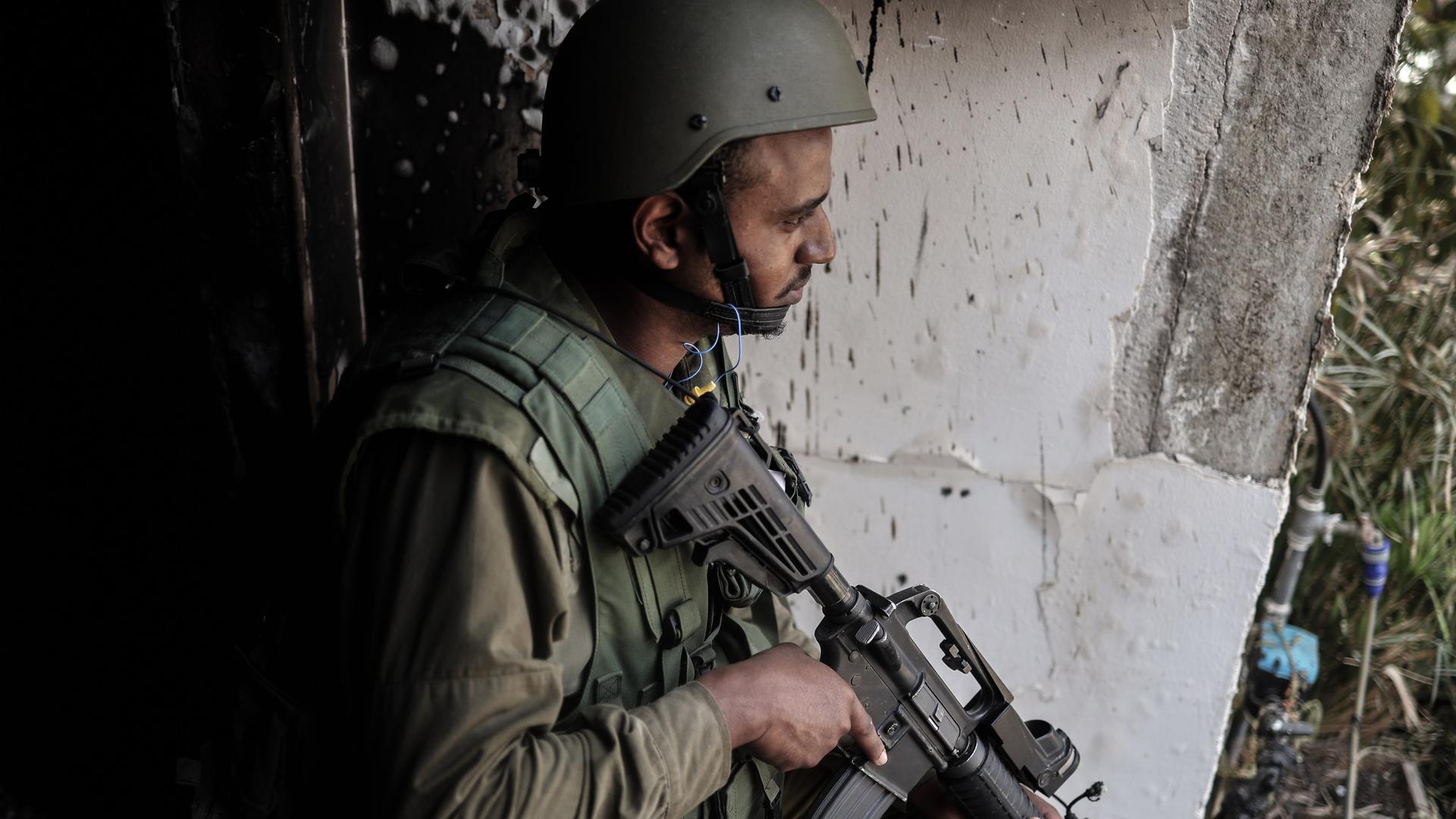 An Israeli soldier stands guard near a destroyed house as fighting between Israeli troops and Islamist Hamas militants continues.