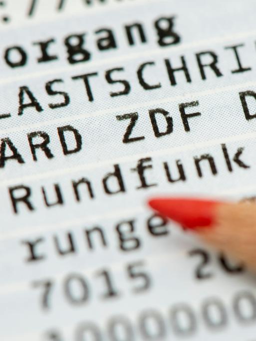 Ein Rotstift liegt auf einem Kontoauszug mit der Lastschrift für den Rundfunkbeitrag für den öffentlich-rechtlichen Rundfunk ARD, ZDF und Deutschlandradio (Symbolbild)