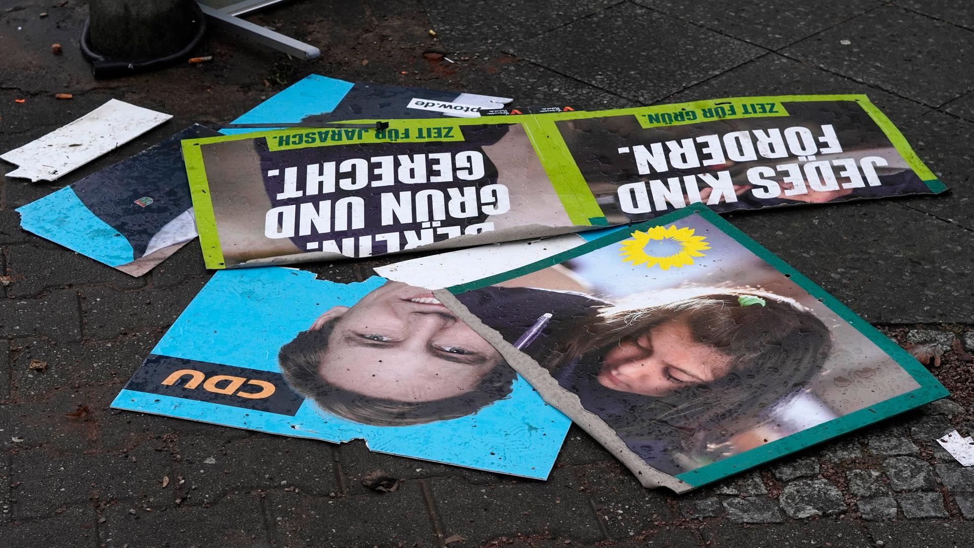 Zerstörte Wahlplakate zur Wiederholungswahl zum Berliner Abgeordnetenhaus liegen auf dem Gehweg.