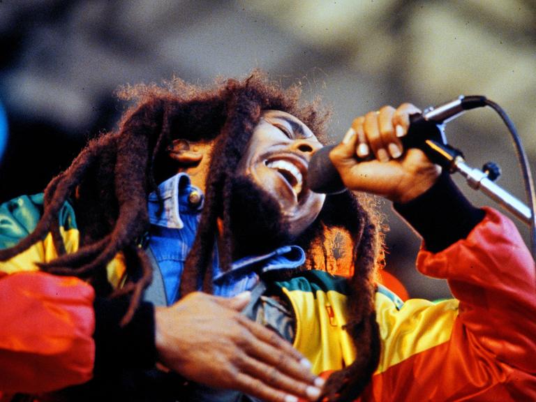 Bob Marley singt mit geschlossenen Augen und fasst sich dabei ans Herz.