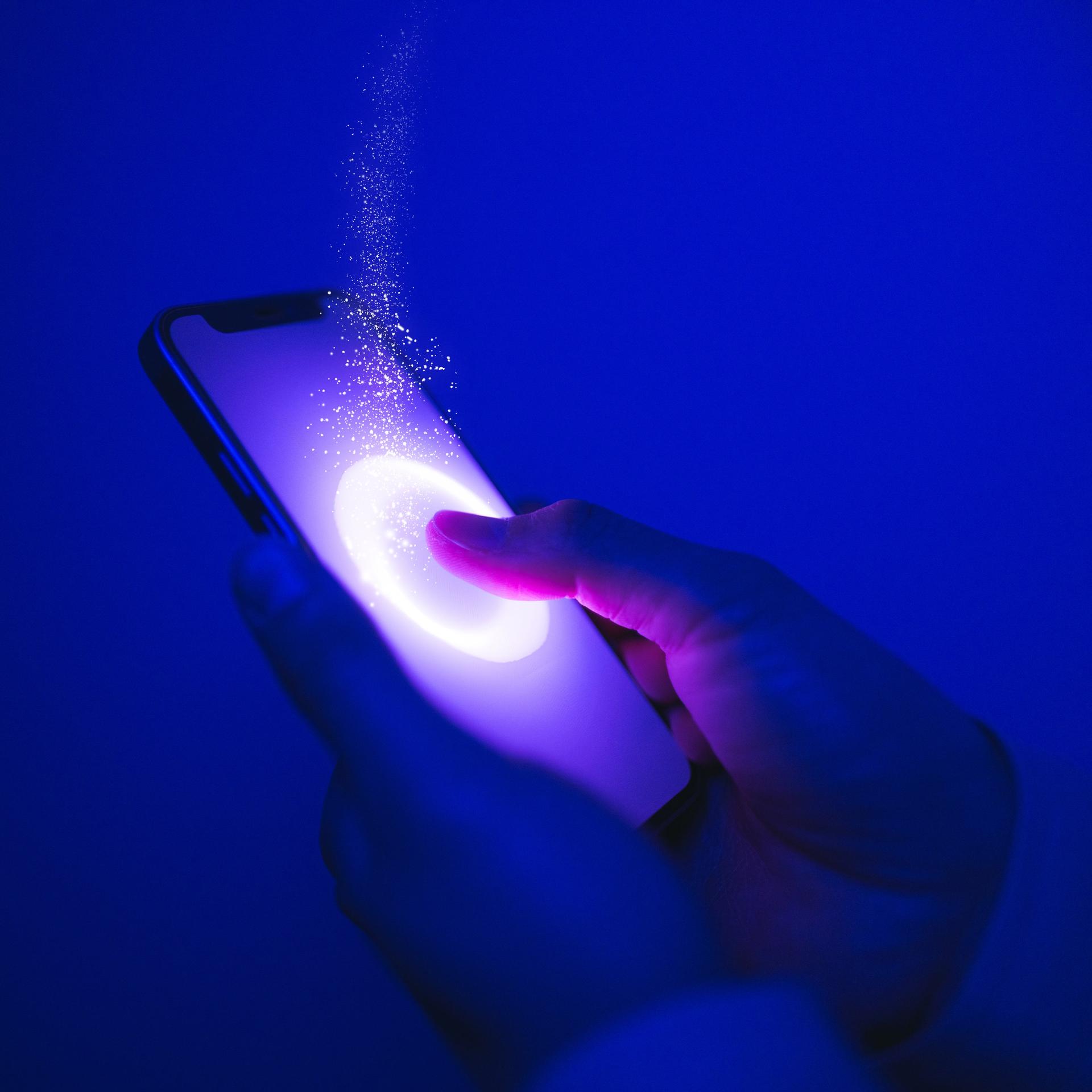 Ein Finger drückt auf einen Smartphone-Bildschirm, es funkelt und blitzt an der Stelle.