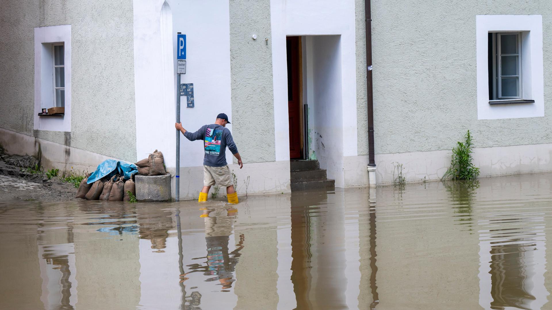 Ein Mann in Gummistiefeln stapft in der Passauer Altstadt durchs Hochwasser. Ein Mann in Gummistiefeln stapft in der Passauer Altstadt durchs Hochwasser.
