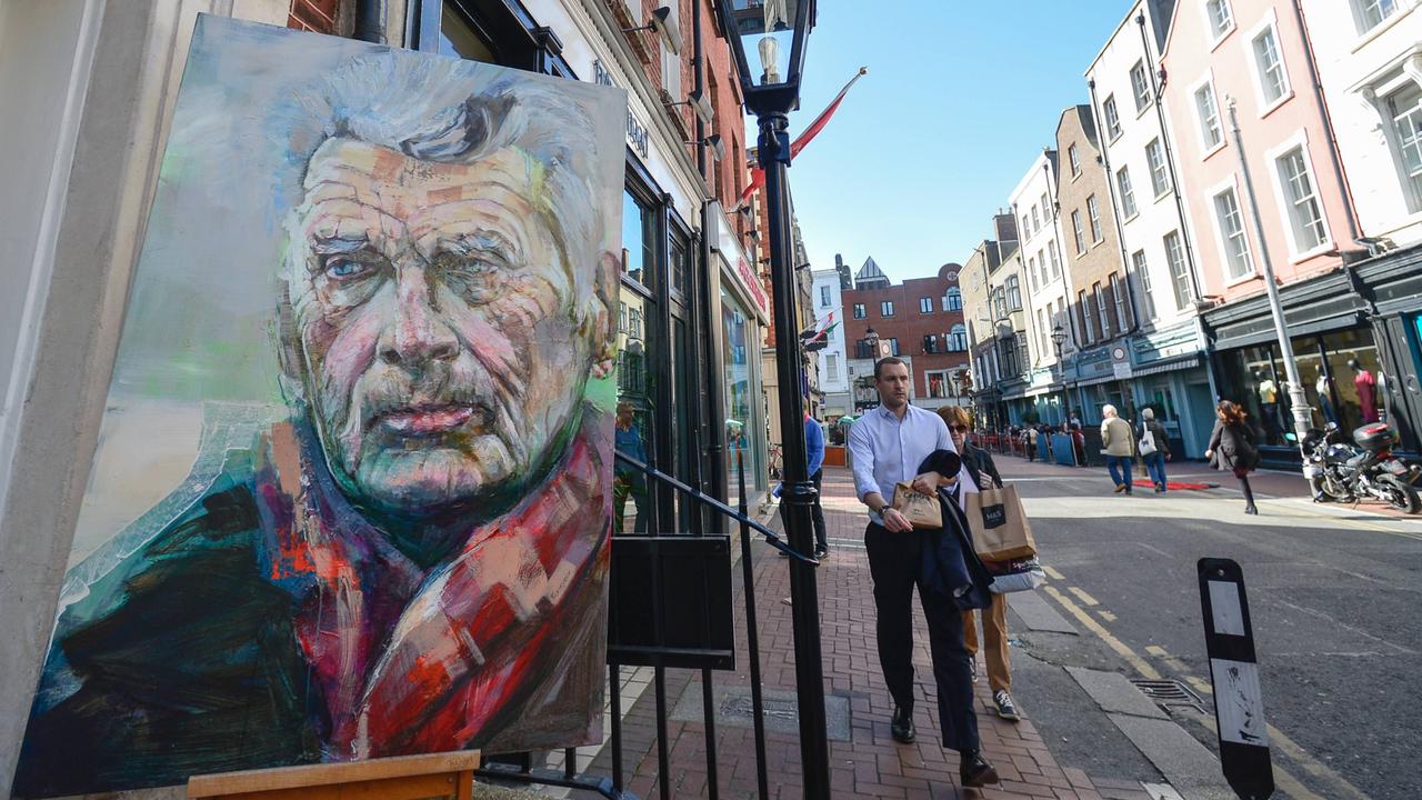 Ansicht einer Straße in der irischen Stadt Dublin. Vor einer Kunstgalerie steht ein Gemälde mit dem Porträt des Schriftstellers Samuel Beckett.