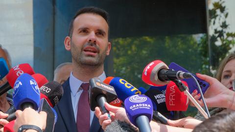 Der Vorsitzende der Partei "Europa Jetzt!", Milojko Spajic, spricht in zahlreiche Reporter-Mikrofone, die ihmhingehalten werden.