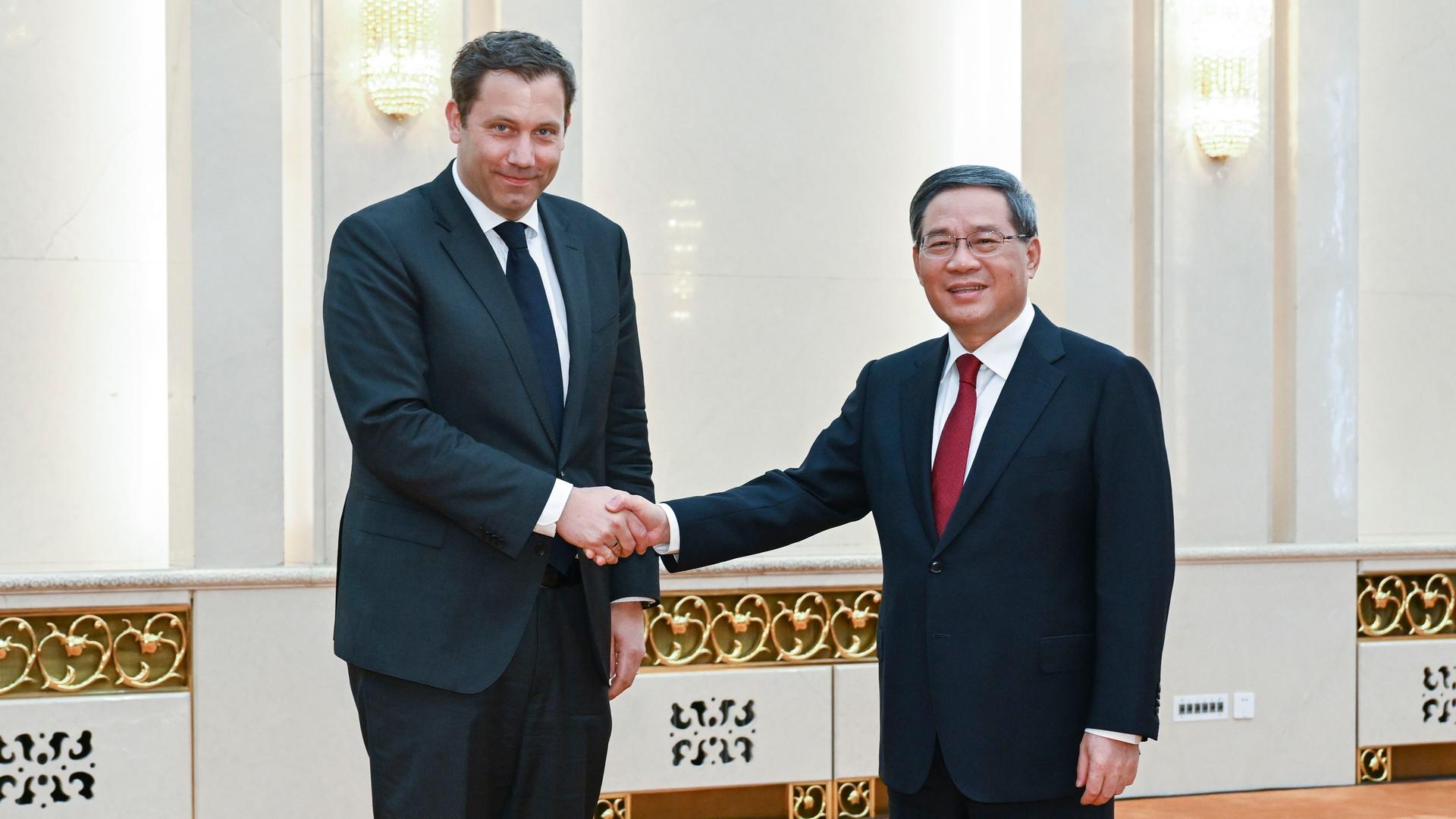 China, Peking: Li Qiang (r), Ministerpräsident von China, begrüßt Lars Klingbeil, SPD-Bundesvorsitzender, in Peking.