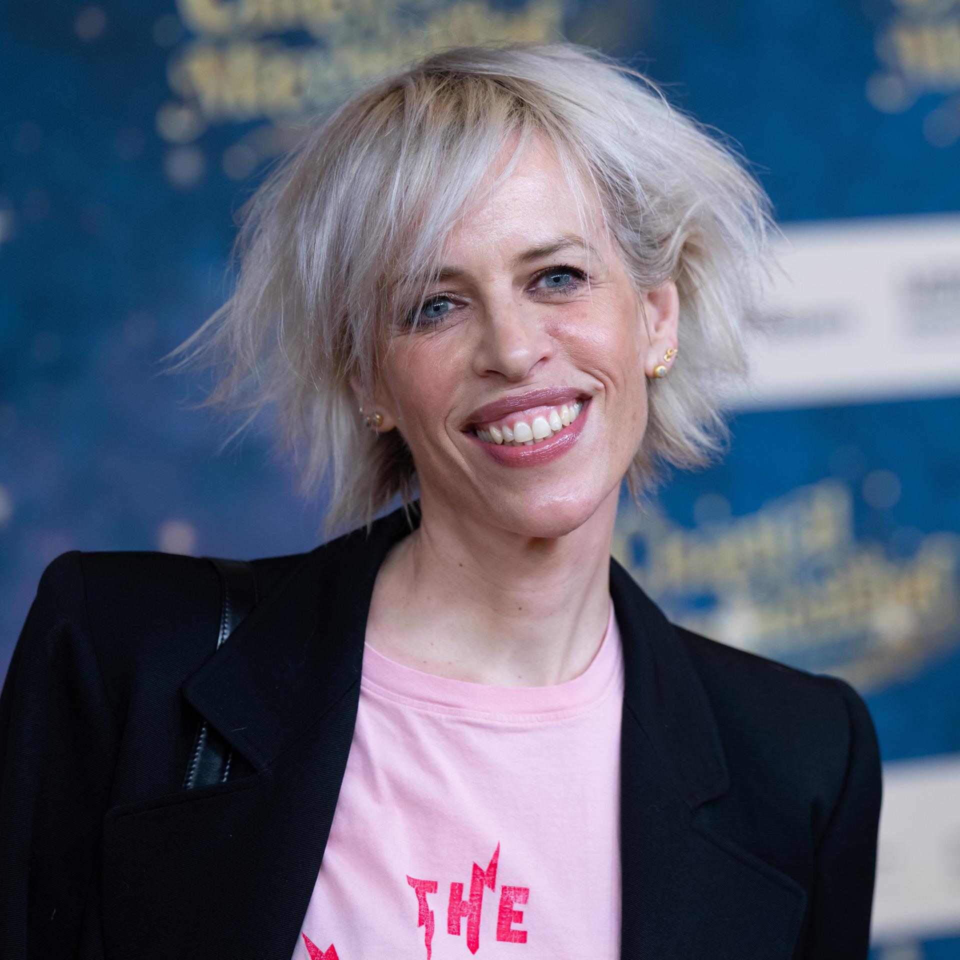 Katja Eichinger, Produzentin, kommt im Mathäser Filmpalast zu der Premiere des Films Chantal im Märchenland. Sie trägt ein rosa Shirt mit Aufdruck und eine schwarze Jacke.