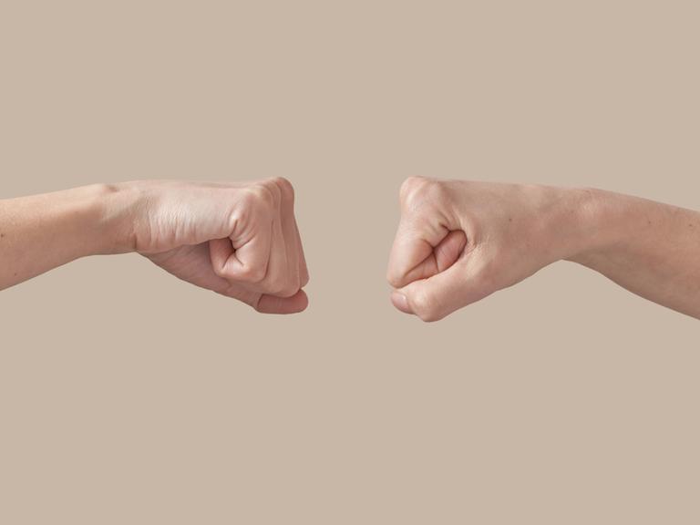 Zwei Fäuste sind sich gegenüber gestellt. Zwei Fäuste sind sich gegenüber gestellt.