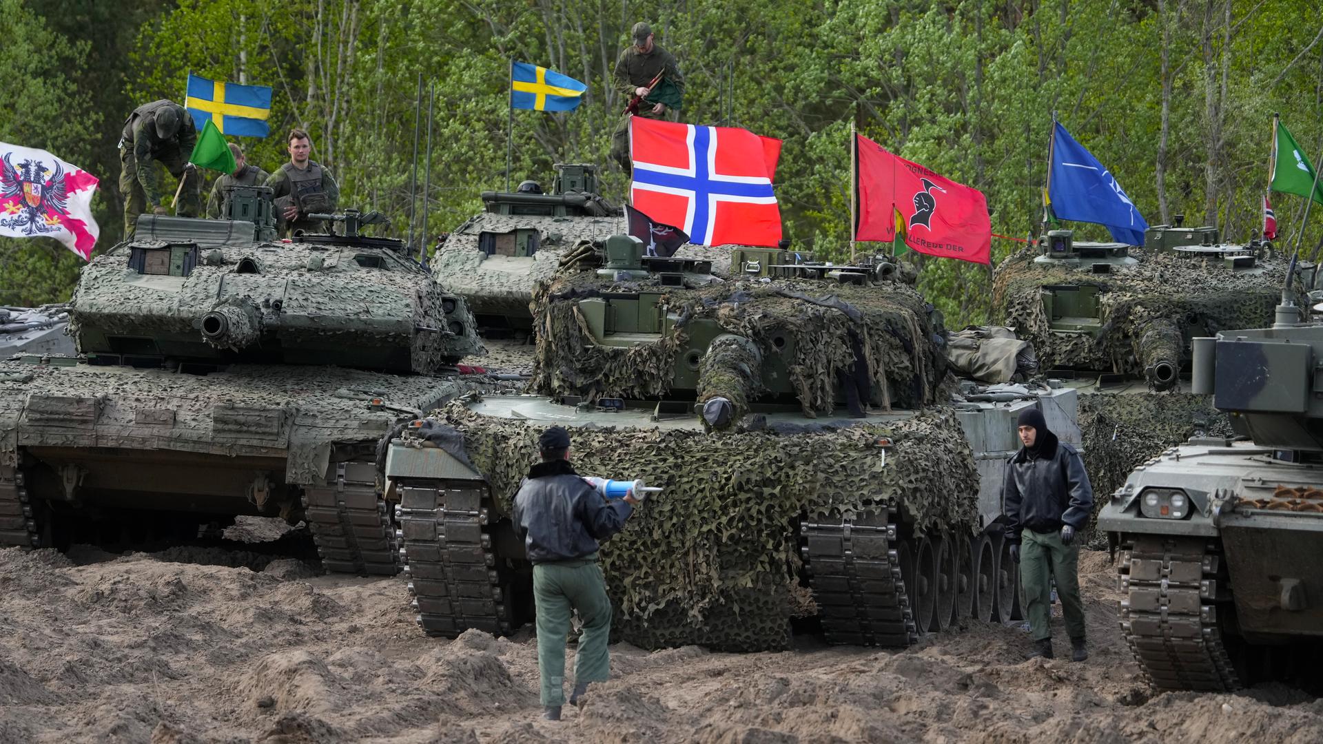 Panzer mit schwedischen, norwegischen und italienischen Flaggen bei einer Übung in einem Waldgebiet. Panzer mit schwedischen, norwegischen und italienischen Flaggen bei einer Übung in einem Waldgebiet.