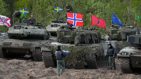 Panzer mit schwedischen, norwegischen und italienischen Flaggen bei einer Übung in einem Waldgebiet. Panzer mit schwedischen, norwegischen und italienischen Flaggen bei einer Übung in einem Waldgebiet.