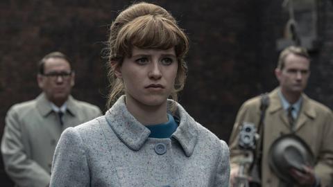 Das Standbild aus der Serie "Deutsches Haus" ist eine Nahaufnahme der Protagonistin, einer jungen Frau mit adretter Hochsteckfrisur, die sehr betreten schaut.