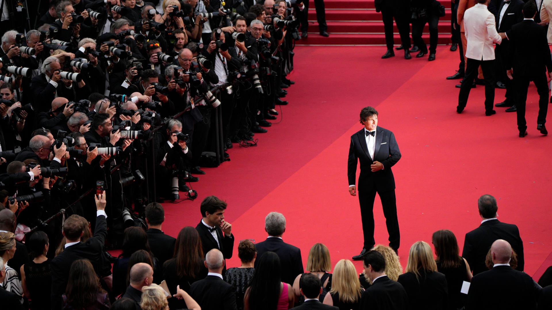 Tom Cruise steht in Cannes vor Fotografen.
