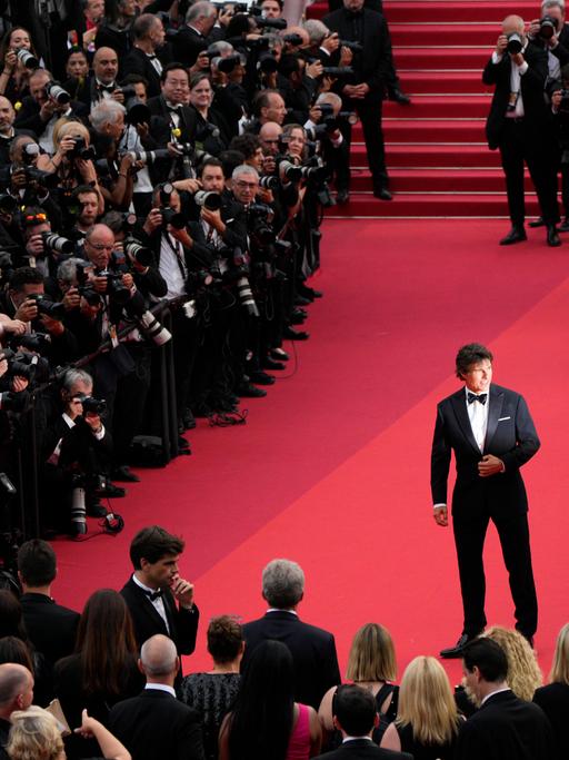 Tom Cruise steht in Cannes vor Fotografen.