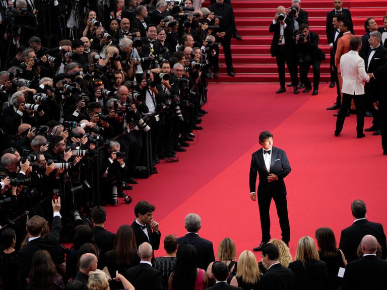 Tom Cruise steht in Cannes vor Fotografen.