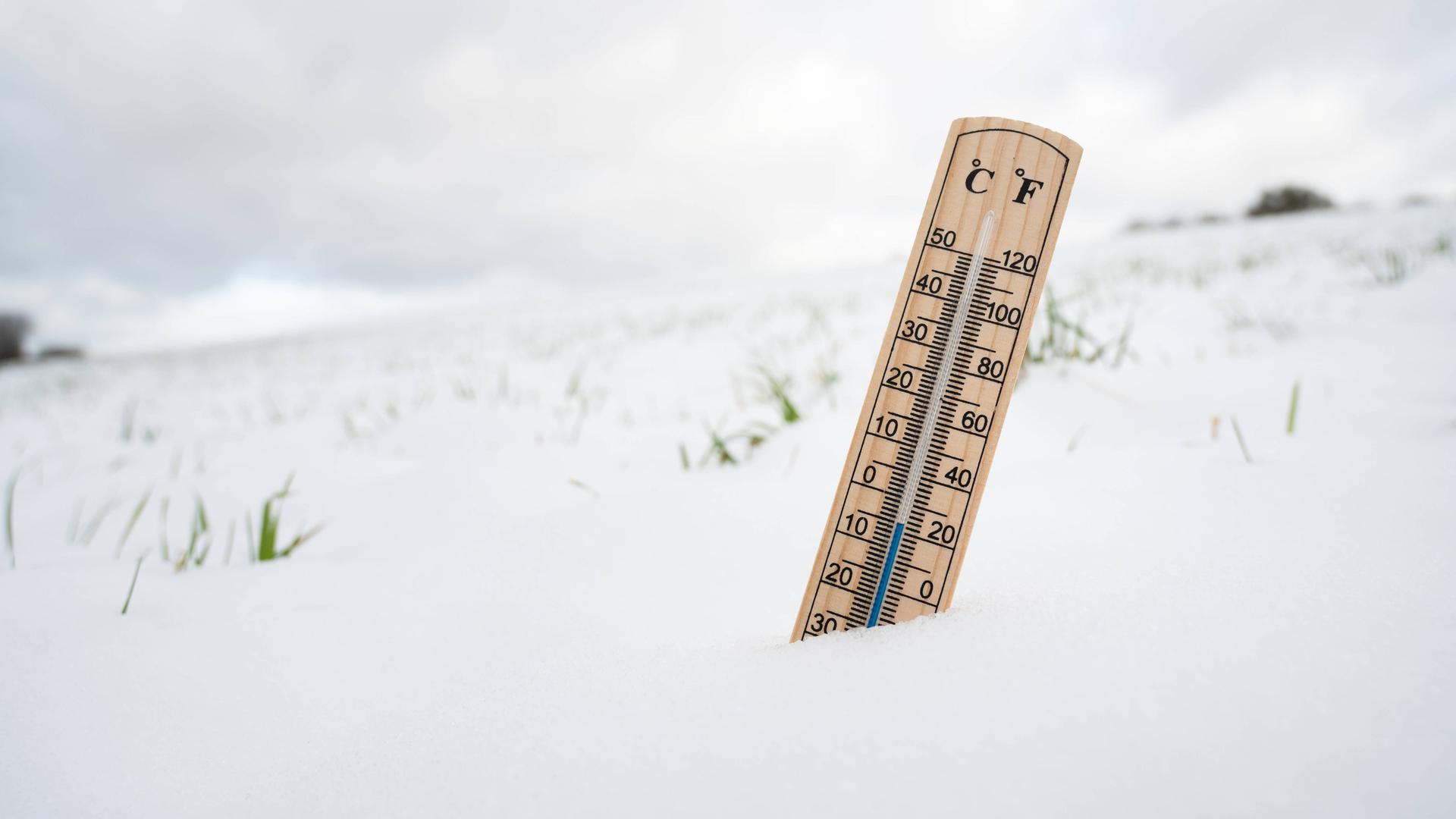 Wir sehen ein Thermometer, das im Schnee steckt. Wir sehen ein Thermometer, das im Schnee steckt.