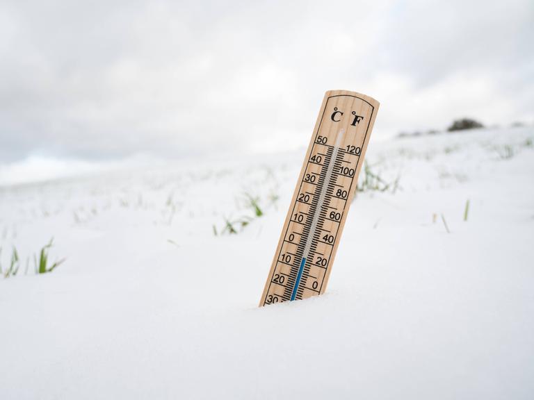 Wir sehen ein Thermometer, das im Schnee steckt. Wir sehen ein Thermometer, das im Schnee steckt.
