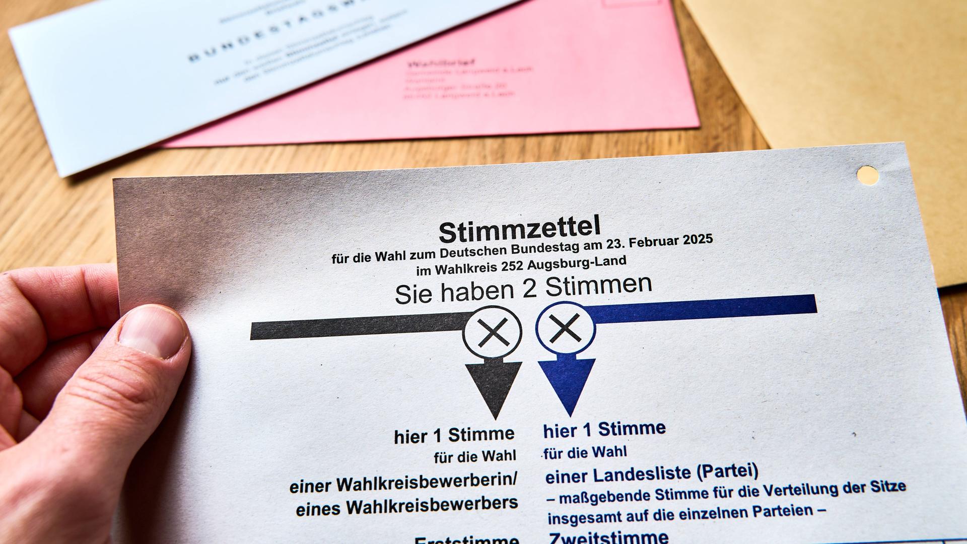 Eine Person hält einen Stimmzettel in der Hand. Er ist Teil der Briefwahlunterlagen für die Bundestagswahl 2025. Eine Person hält einen Stimmzettel in der Hand. Er ist Teil der Briefwahlunterlagen für die Bundestagswahl 2025.
