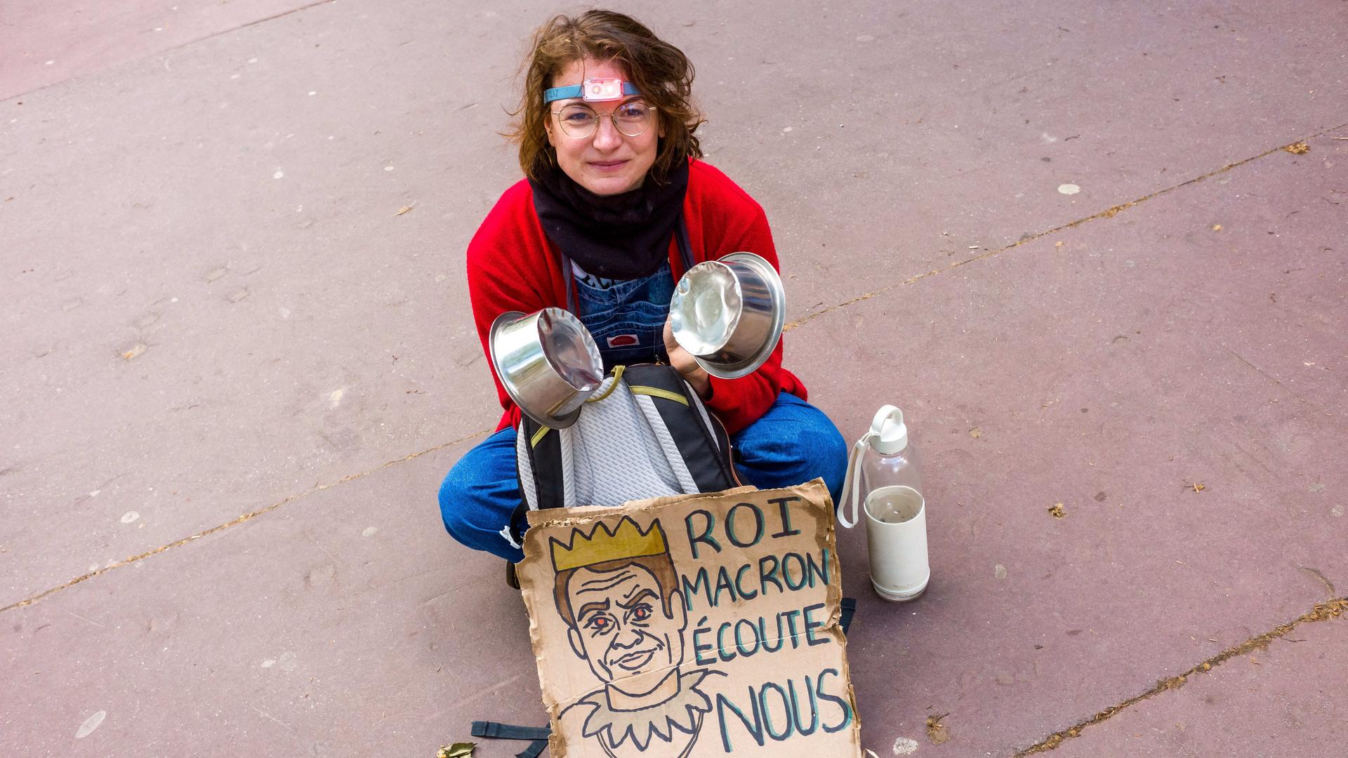 Eine junge Frau mit einem Plakat: "König Macron - hör uns zu". Streik und Demonstration am 1. Mai 2023. Frankreich, Toulouse am 1. Mai 2023.