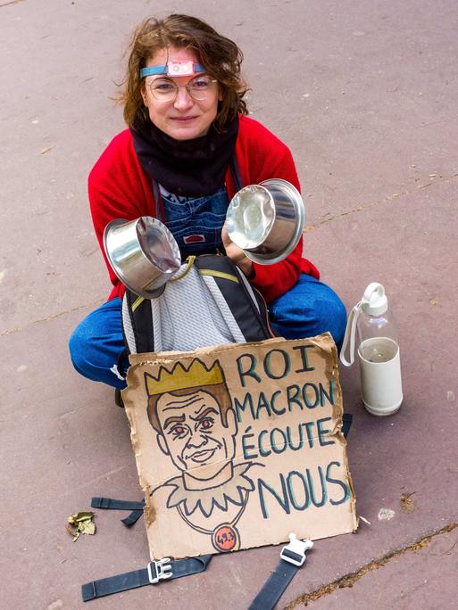 Eine junge Frau mit einem Plakat: "König Macron - hör uns zu". Streik und Demonstration am 1. Mai 2023. Frankreich, Toulouse am 1. Mai 2023.