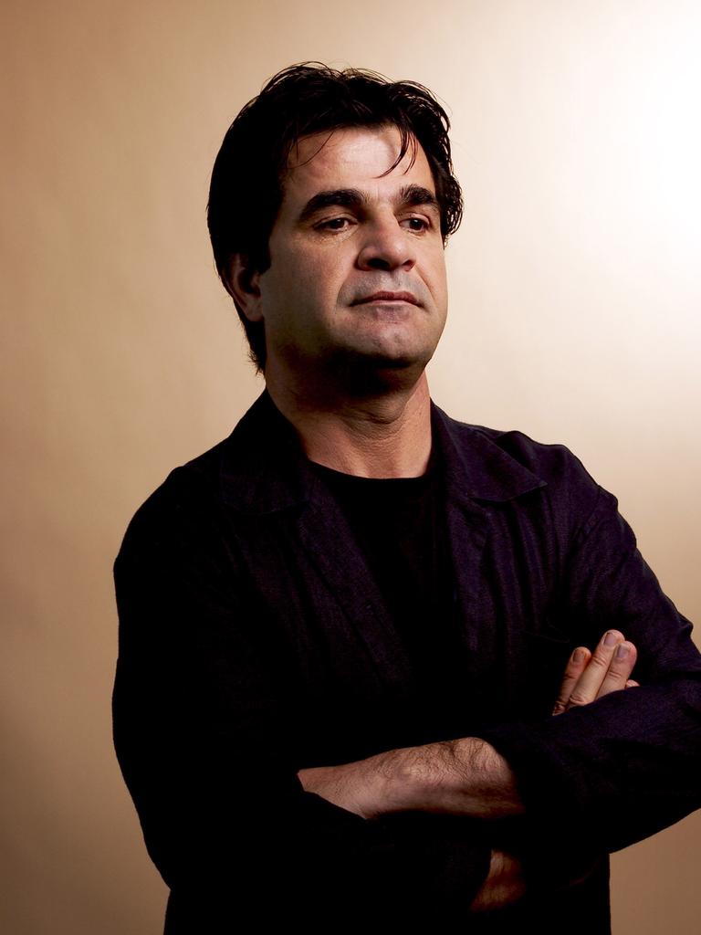Porträt von Jafar Panahi mit verschränkten Armen und nachdenklichem Gesichtsausdruck.
