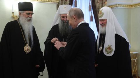 Das Bild zeigt drei Geistliche im Gespräch mit Wladimir Putin. Konkret: Bischof Irinej von Backa, den serbischen Patriarchen Porfirije und Patriarch Kirill von Moskau. 