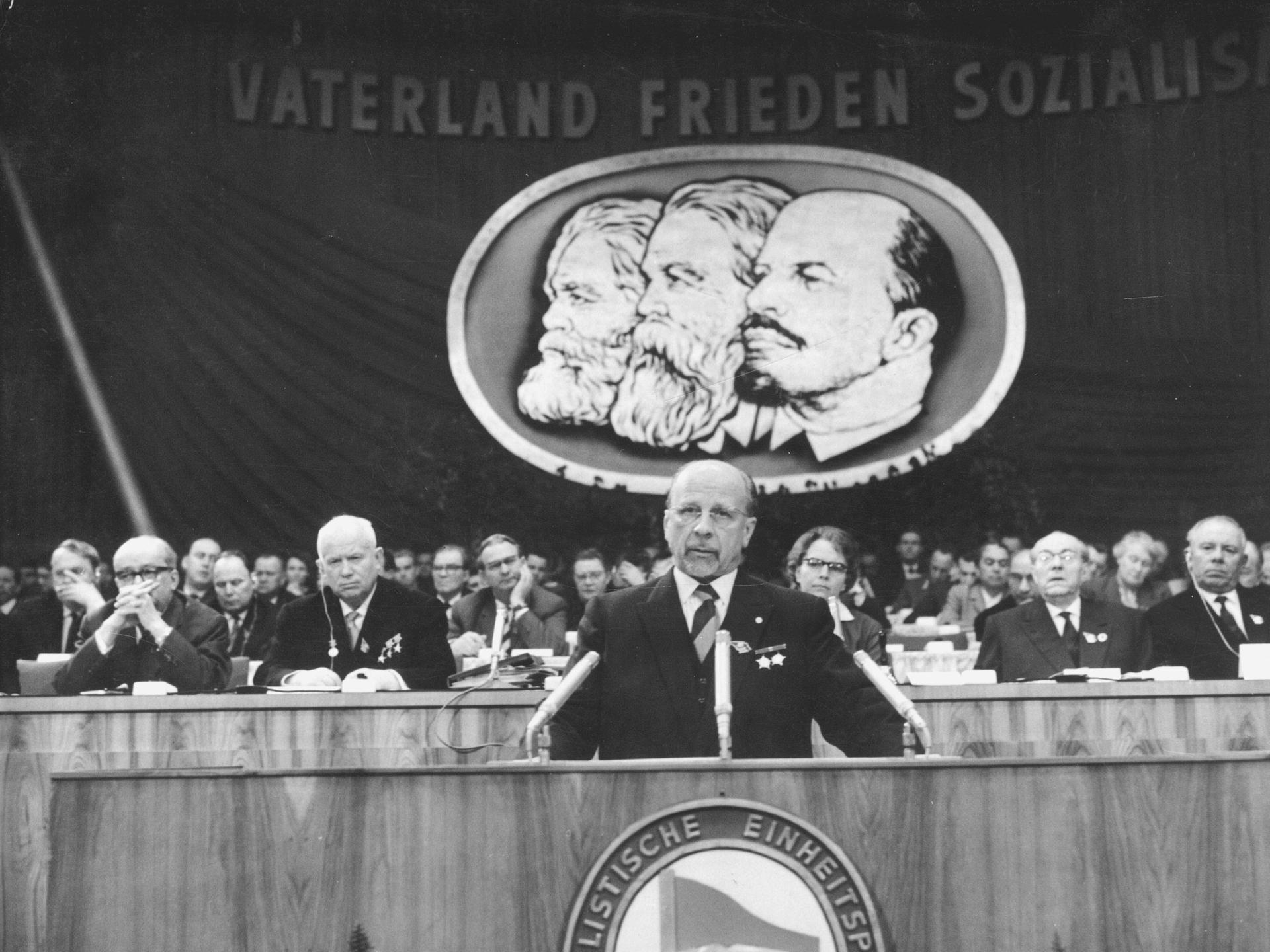 Historisches Schwarzweißfoto von Walter Ulbricht am Rednerpult während eines Parteitags der SED.