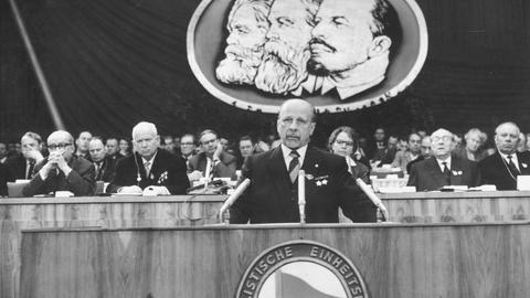 Historisches Schwarzweißfoto von Walter Ulbricht am Rednerpult während eines Parteitags der SED. Historisches Schwarzweißfoto von Walter Ulbricht am Rednerpult während eines Parteitags der SED.