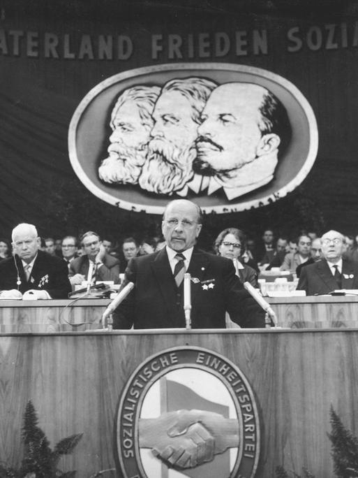 Historisches Schwarzweißfoto von Walter Ulbricht am Rednerpult während eines Parteitags der SED.