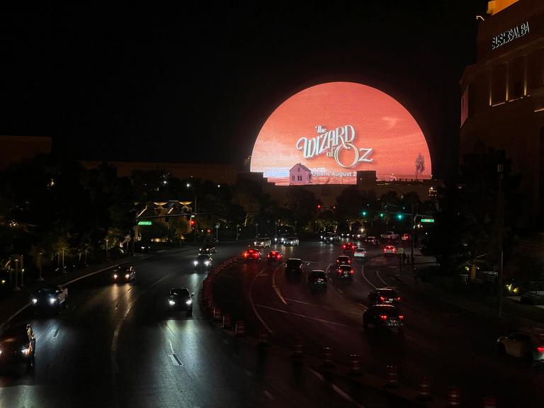 Der Veranstaltungsort "The Sphere" in Las Vegas bei Nacht - erleuchtet mit der Ankündigung "The Wizard of Oz - opens August 28"