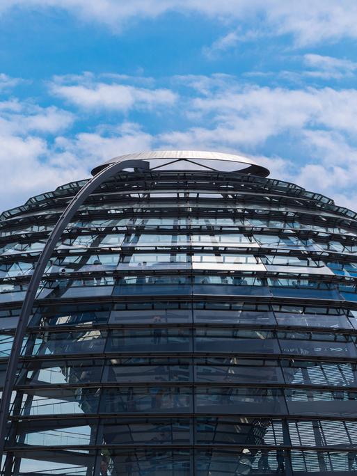 Die Glas-Kuppel auf dem Gebäude des deutschen Bundestages vor leicht bewölktem Himmel.