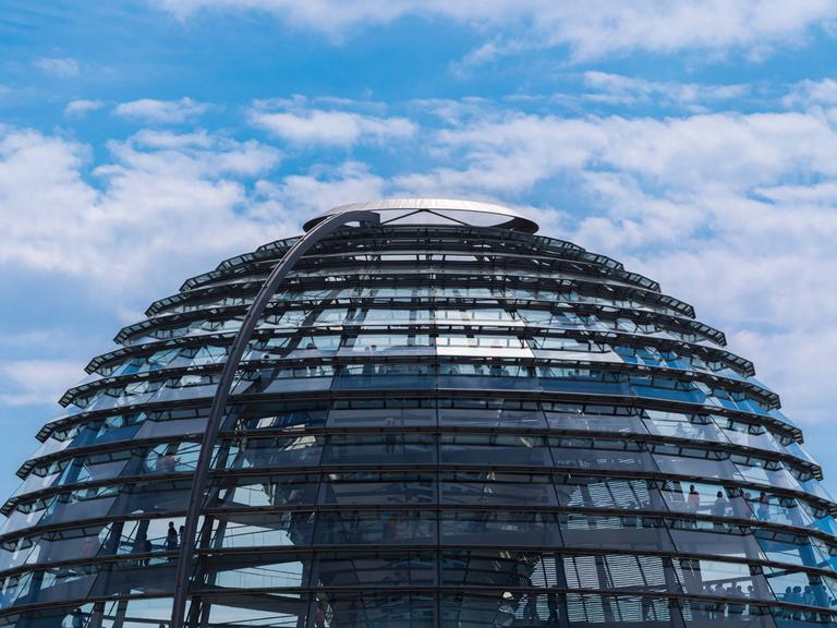 Die Glas-Kuppel auf dem Gebäude des deutschen Bundestages vor leicht bewölktem Himmel.