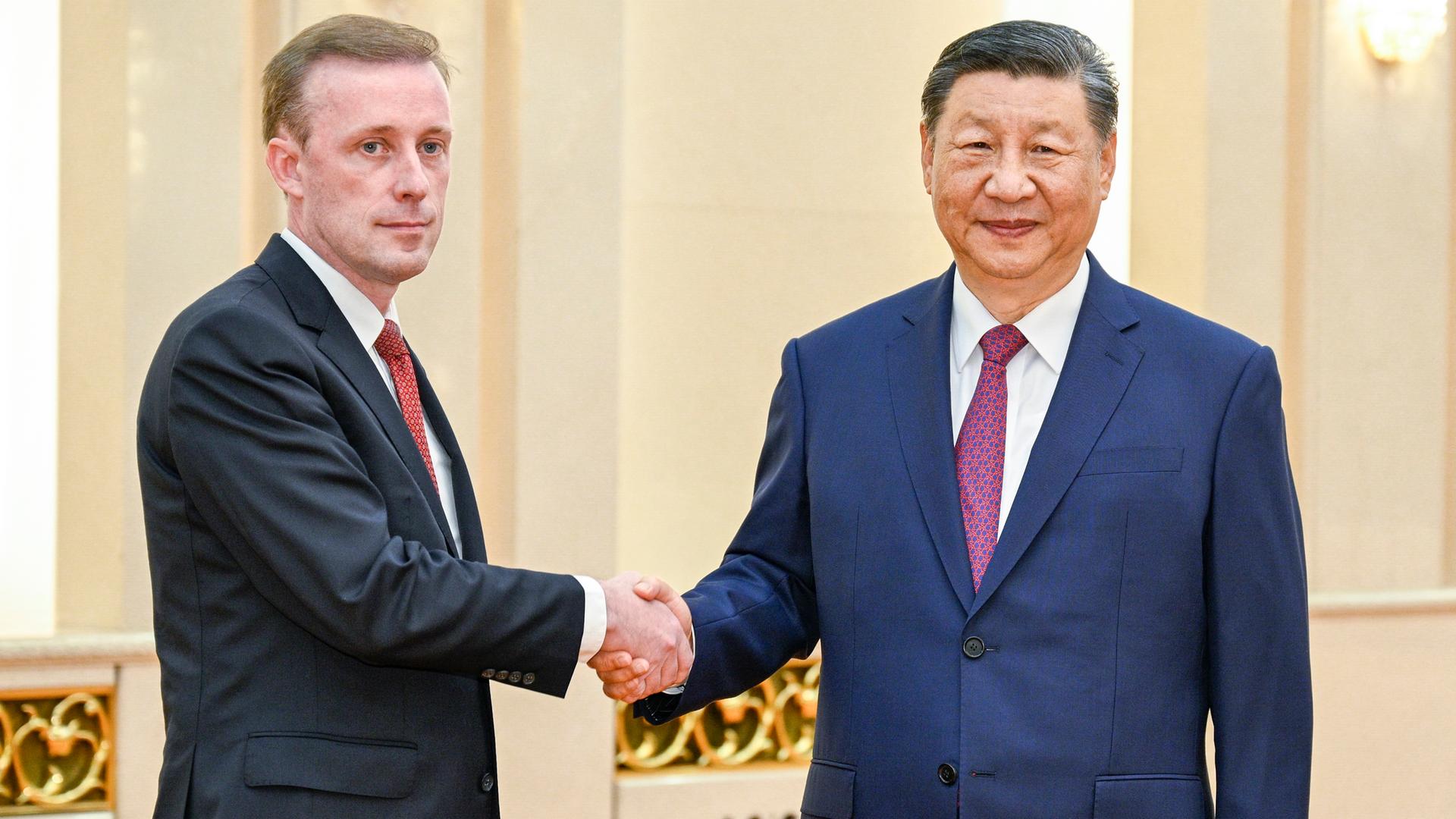 Peking: Der chinesische Präsident Xi Jinping (r) trifft sich mit dem nationalen Sicherheitsberater der USA, Jake Sullivan, in der Großen Halle des Volkes. Sie schütteln sich die Hände.