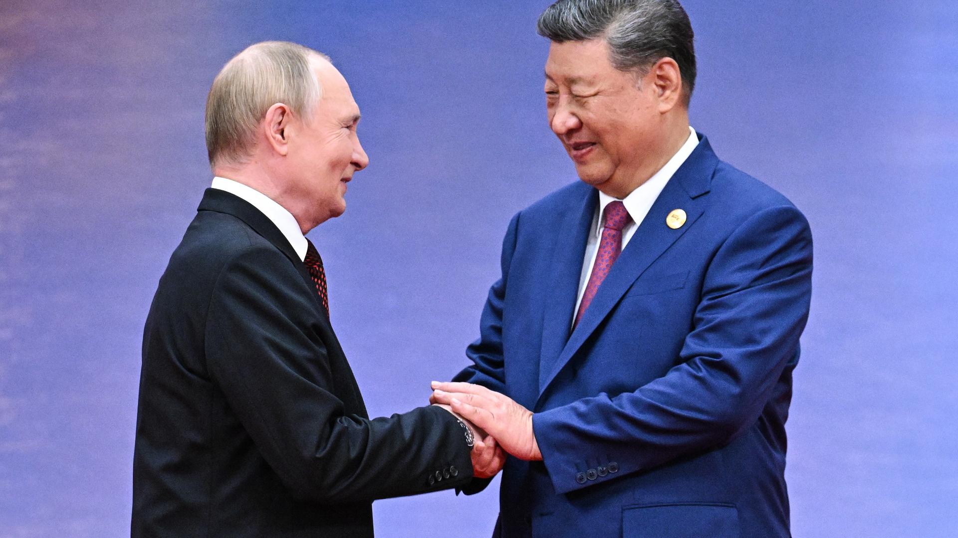 Xi Jinping schüttelt Putin bei einem Empfang die Hände