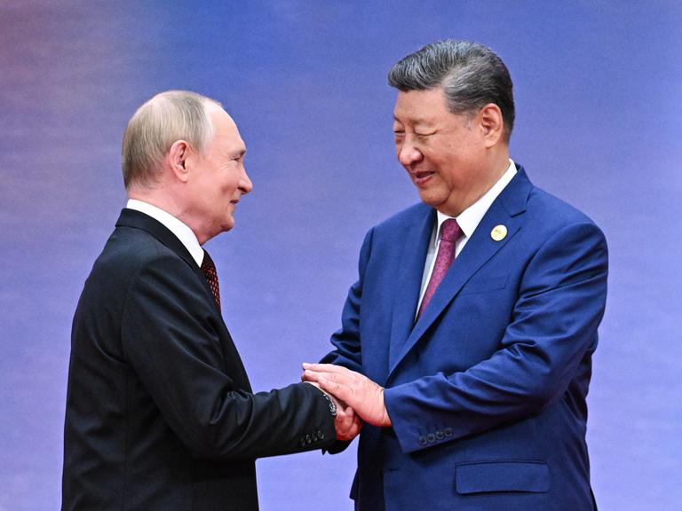 Xi Jinping schüttelt Putin bei einem Empfang die Hände