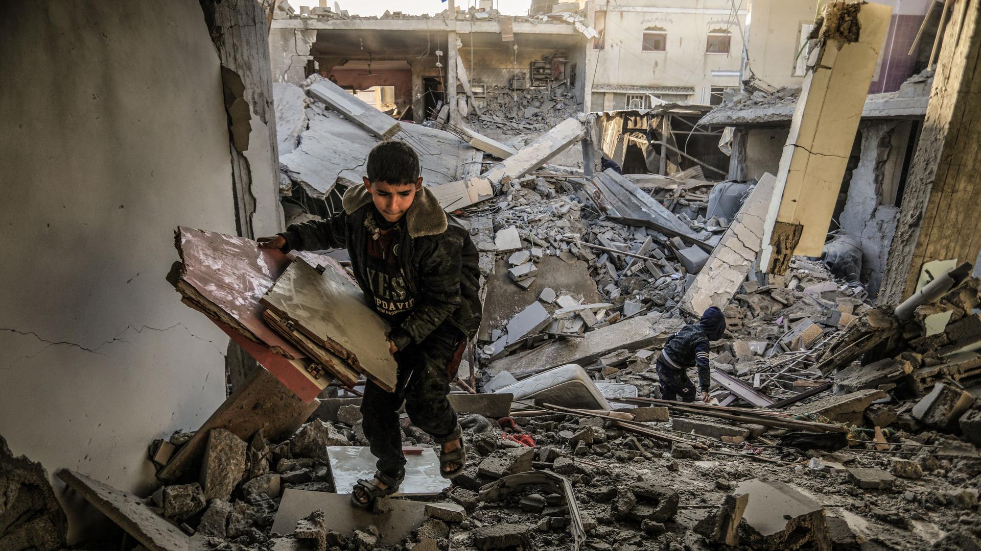 Palästinensische Kinder schauen sich ein kaputtes Haus nach einem israelischen Luftangriff im Gaza-Streifen an. 