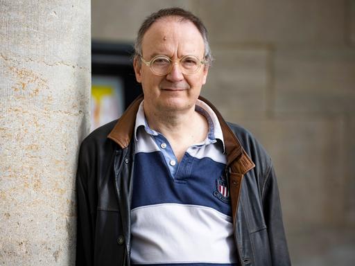 Thomas Brussig posiert in Polohemd und Nappalederjacke im Freien für ein Porträt.