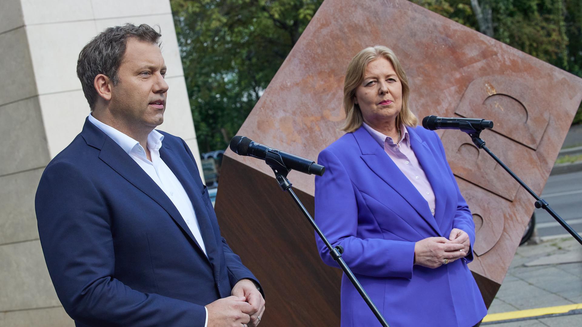 Die SPD-Vorsitzenden Klingbeil und Bas stehen vor dem Eingangsbereich des Willy-Brandt-Hauses in Berlin und sprechen in Mikrofone. Die SPD-Vorsitzenden Klingbeil und Bas stehen vor dem Eingangsbereich des Willy-Brandt-Hauses in Berlin und sprechen in Mikrofone.