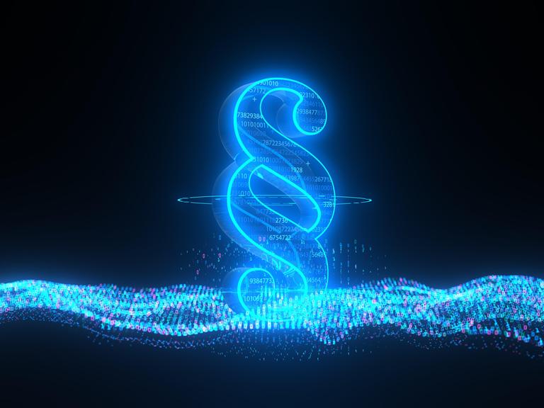 In einer 3-D-Illustration ist ein großer, blau-leuchtender Paragraf abgebildet.