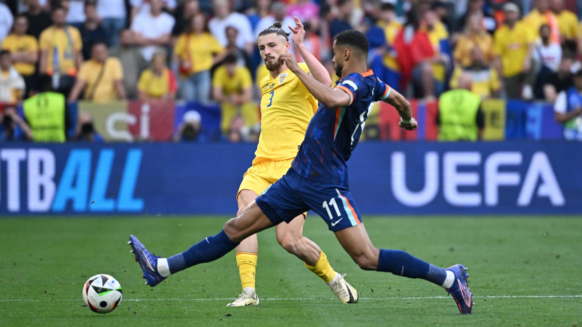 Euro 2024, Achtelfinale: Rumäniens Radu Dragusin (l) und Cody Gakpo von den Niederlanden kämpfen um den Ball. 
